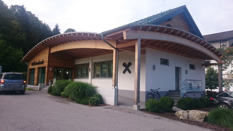 Raiffeisenbank building with wooden cladding and curved roof.