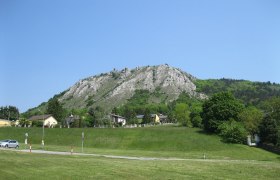 View of the Braunsberg with houses in the foreground and blue sky.