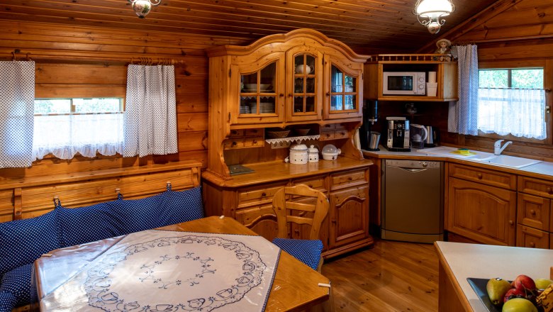 Cozy wooden kitchen with dining area, blue upholstery and tablecloth. Rustic furniture, dishwasher, microwave and coffee machine available.