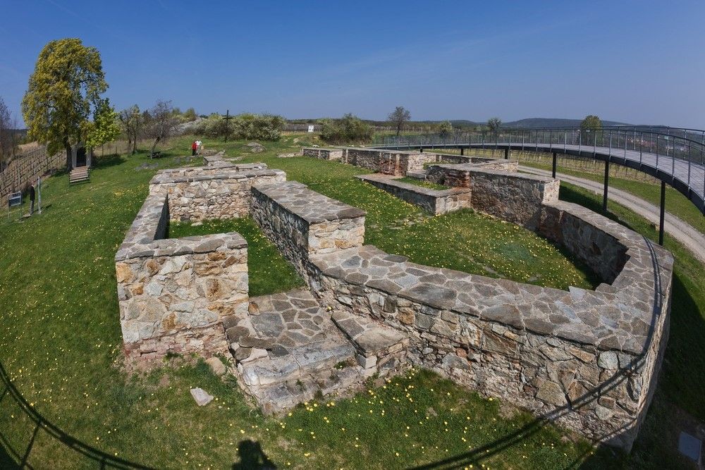 Excavation site with stone walls and outdoor viewing platform.