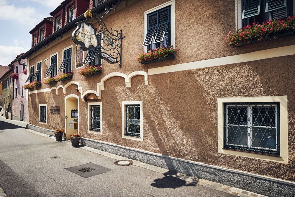 Traditional inn with flower boxes and decorative sign.