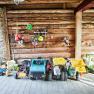 Toy vehicles and helmets in a woodshed.