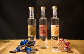 Three bottles of brandy with medals on a table.