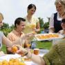 Group of people tasting apricot products outdoors.