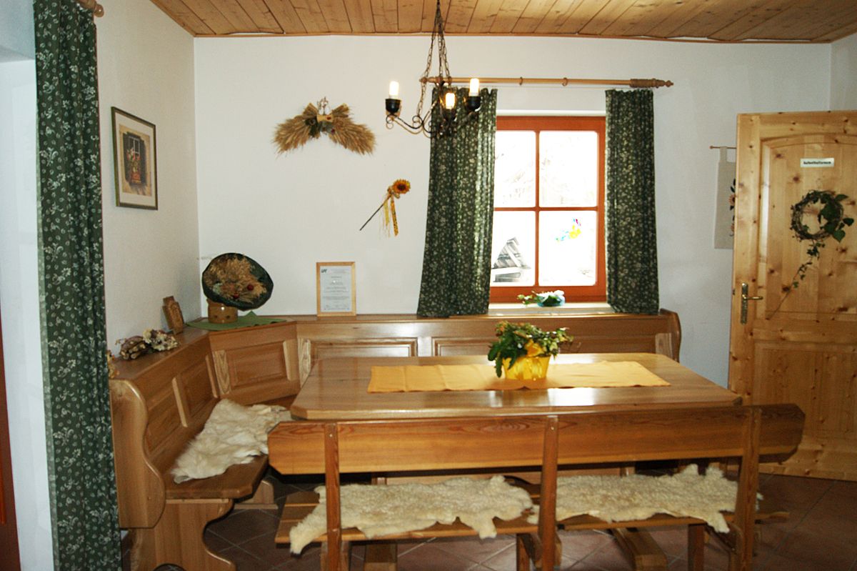 Cozy lounge with wooden furniture, table, corner bench and decorations on the wall.