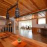 Interior view of a rustic dining room with wooden tables and ceilings, bar area and large windows.