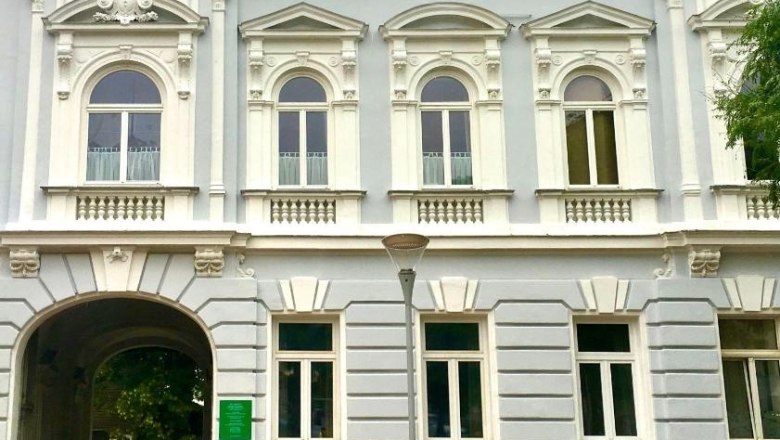 Historic building with ornate windows and an archway.