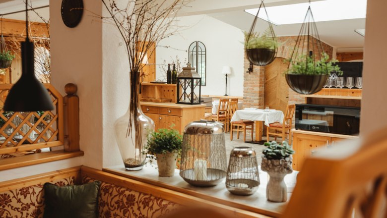 Cozy restaurant with wooden furniture and plants.