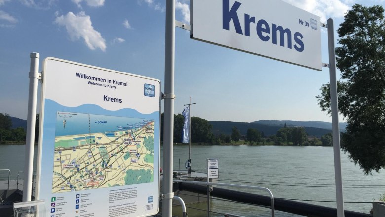 Jetty in Krems with welcome sign and map, river in the background.