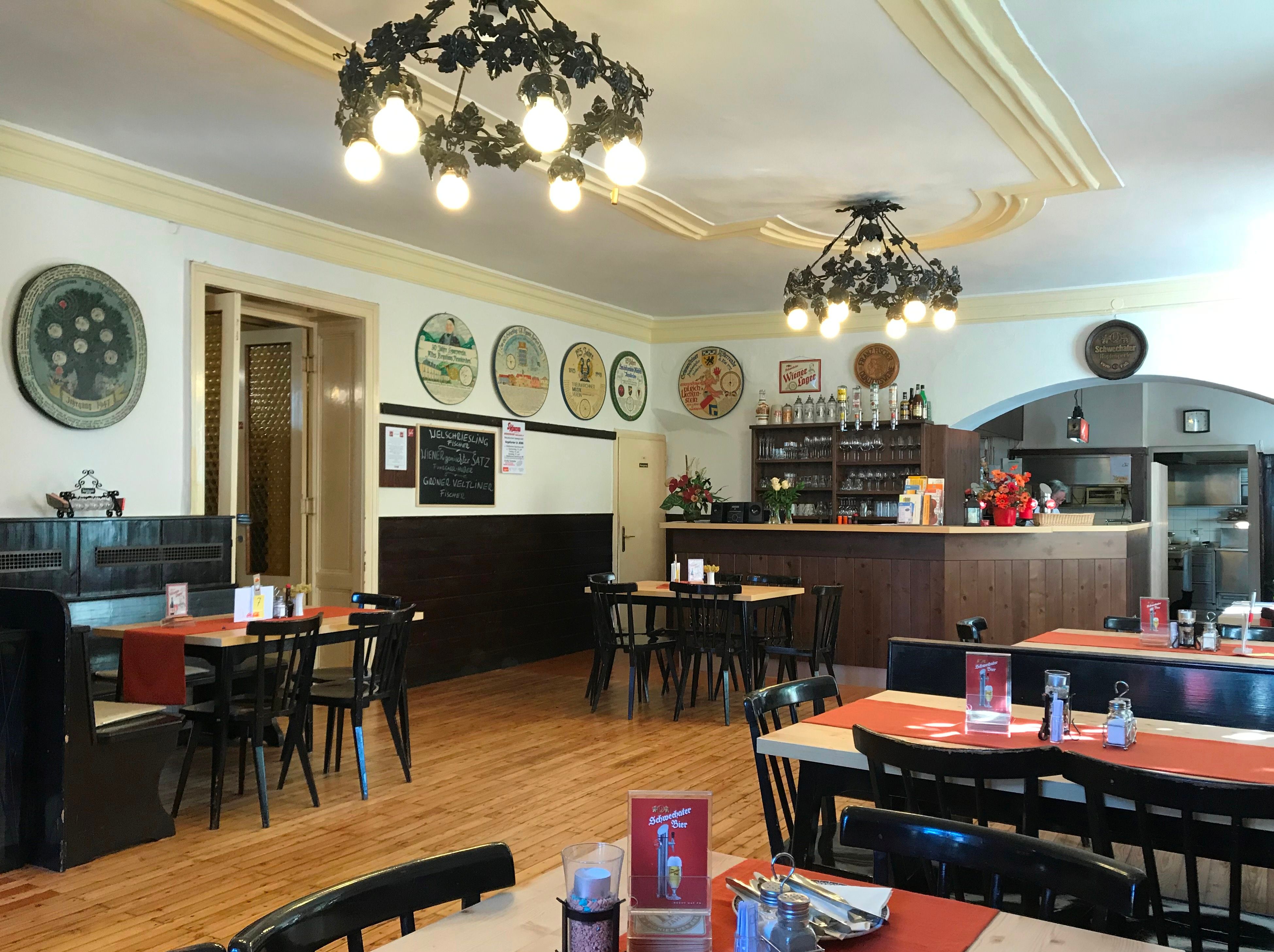 Interior view of a traditional brewery with wooden furniture and decorative wall plates.