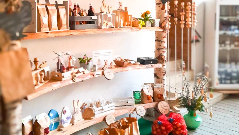 A shelf with various handmade products and food in a small store.