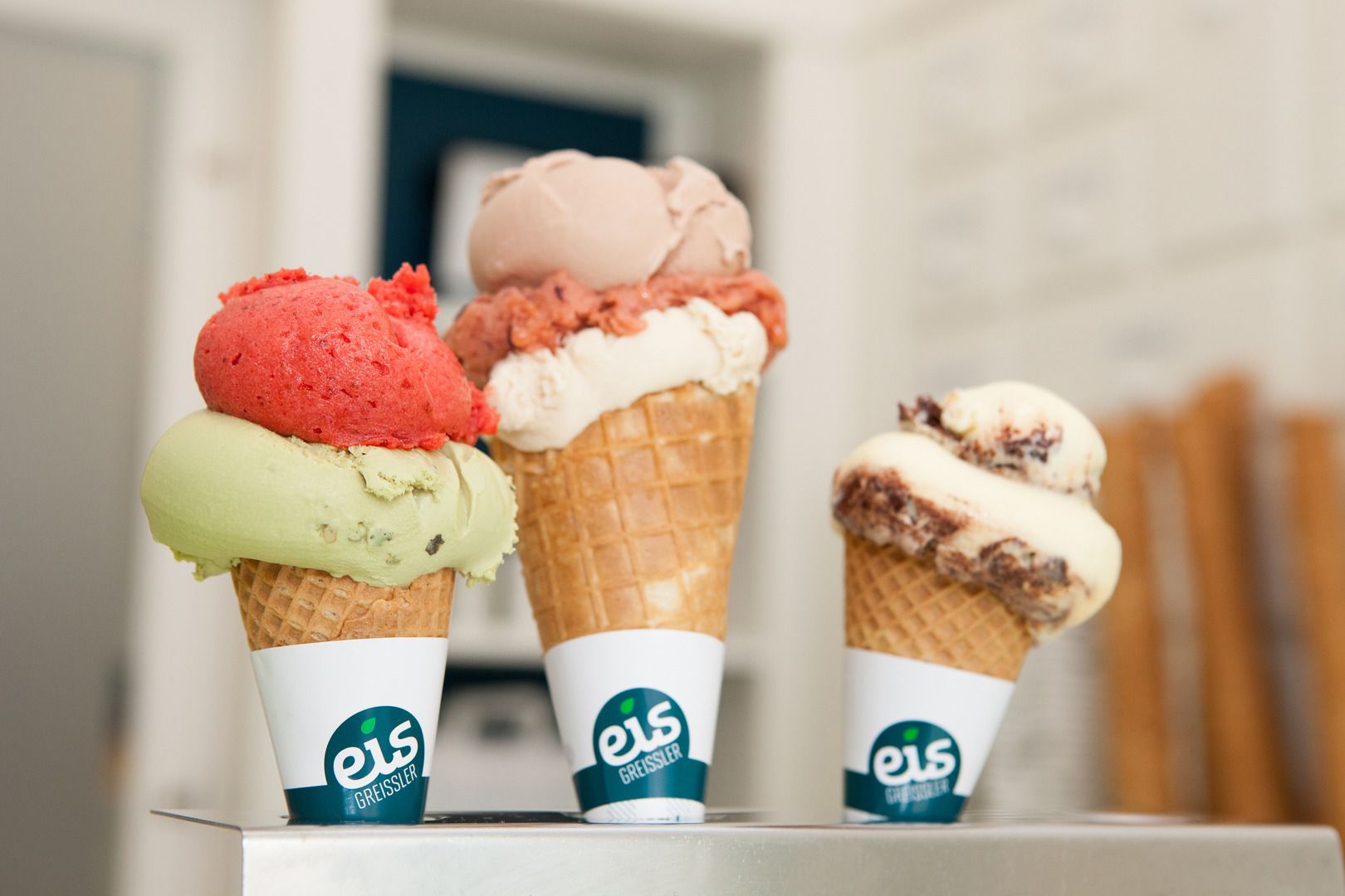 Three ice cream cones with different ice cream flavors from Eis Greissler.