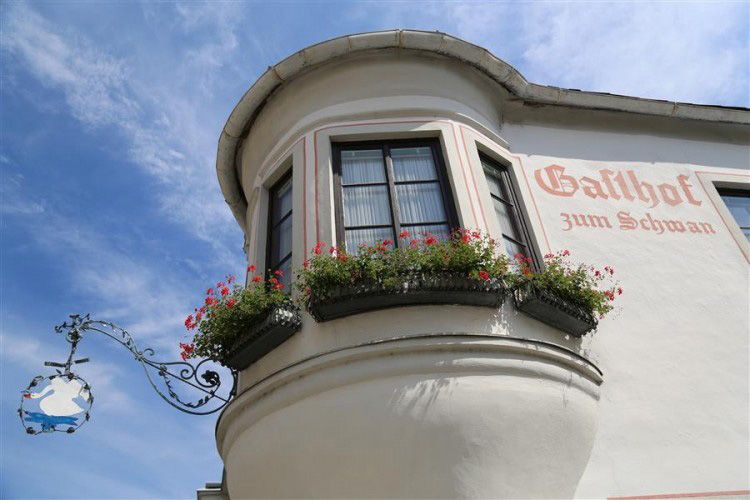 Facade of the Gasthof zum Schwan with bay window and flower boxes.