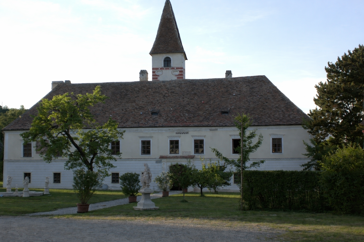 Limberg Castle with garden and statues in the foreground.