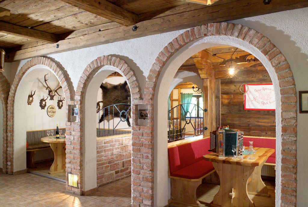 Rustic dining room with wooden furniture, brick arches and hunting trophies on the walls.