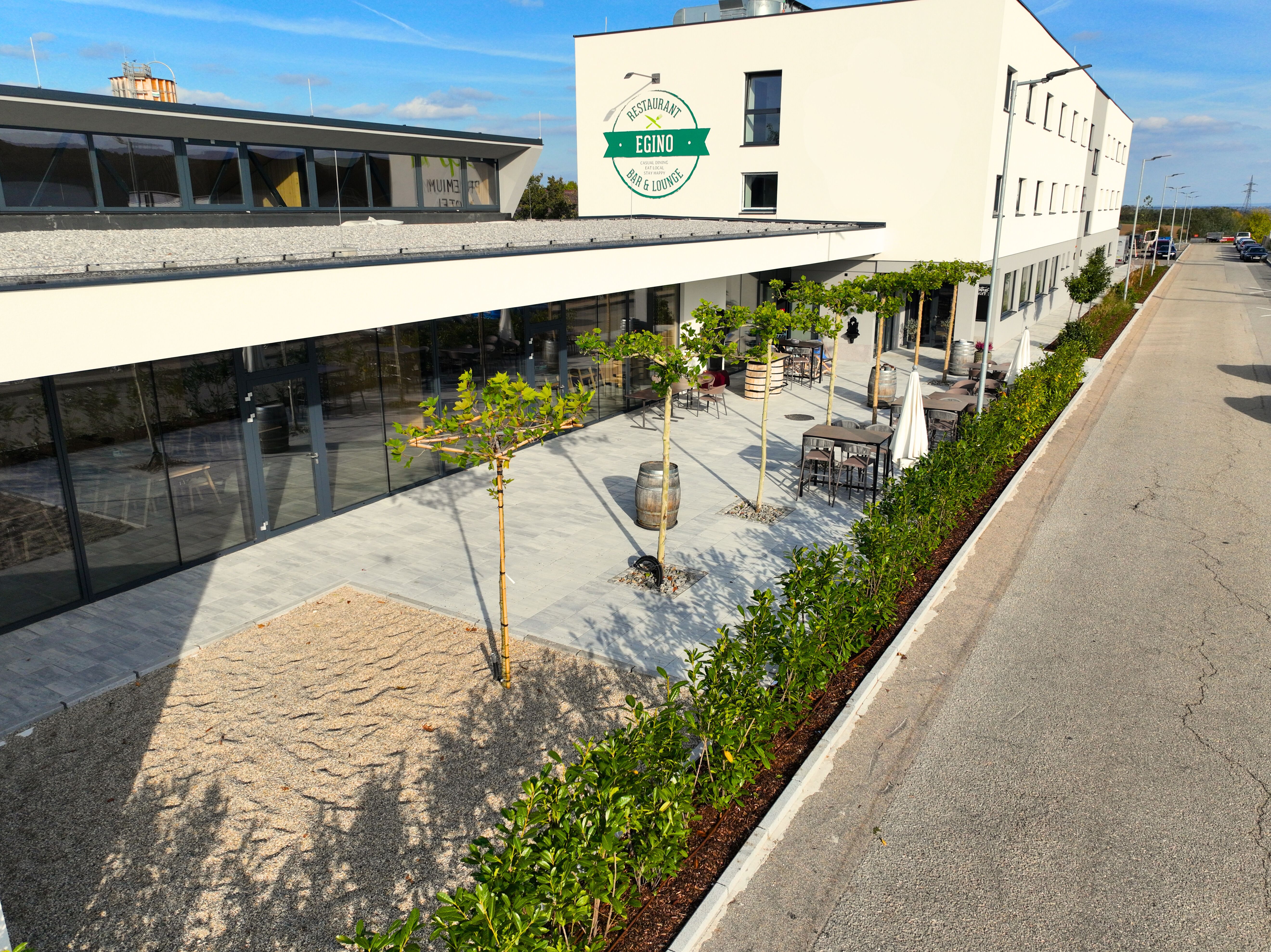 Exterior view of a modern building with terrace and plants.