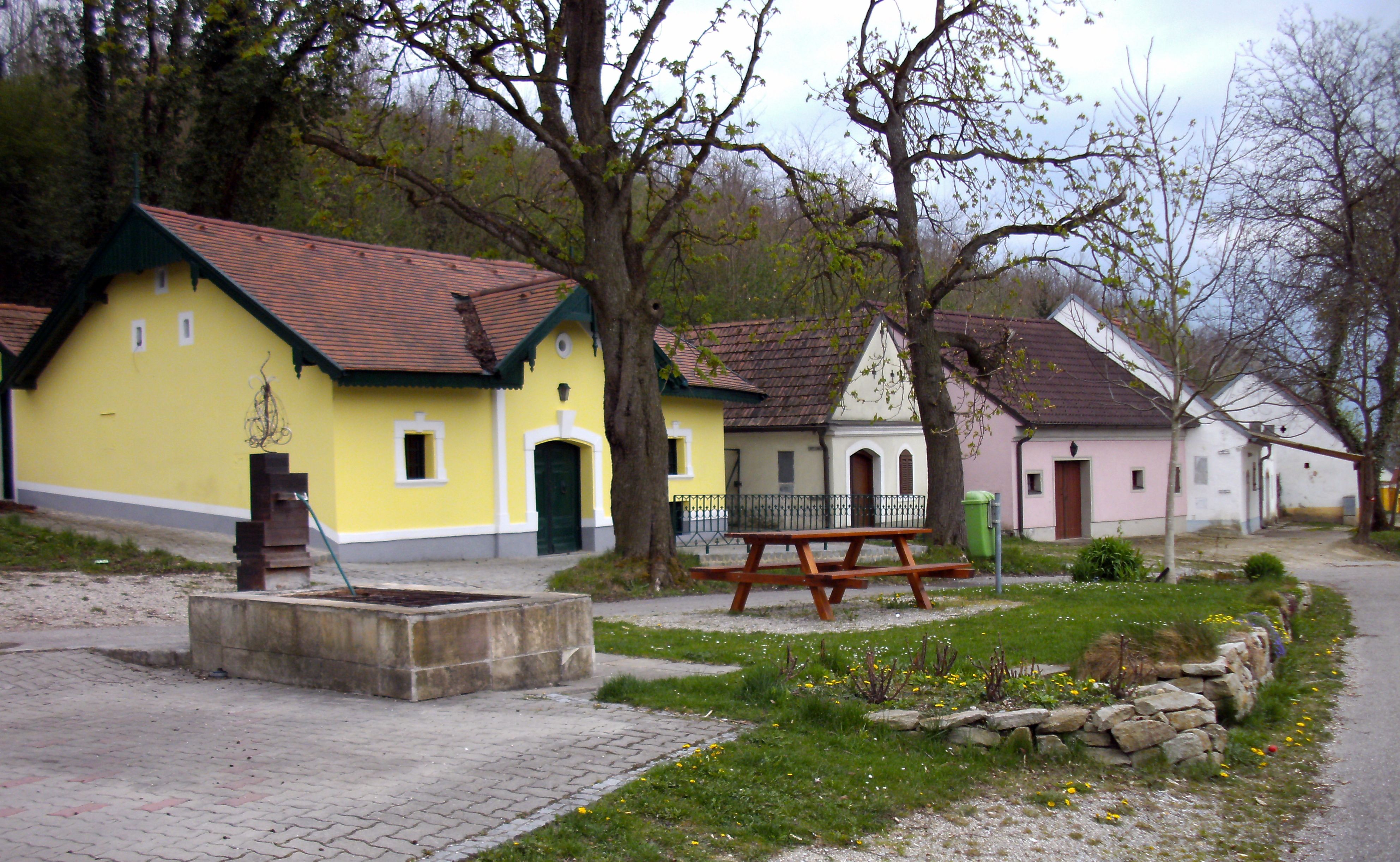 Wine cellar lane in Absdorf with colorful houses and trees.