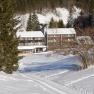 Snow-covered hotel in a mountain landscape with fir trees.