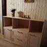Wooden chest of drawers with decoration in a room with wood paneling.