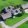 Aerial view of a farm with several buildings and green meadows.