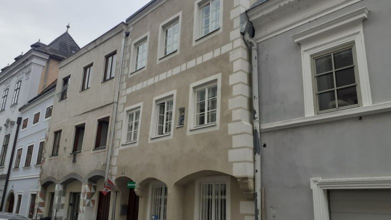 Terraced houses in a European town with a paved street.