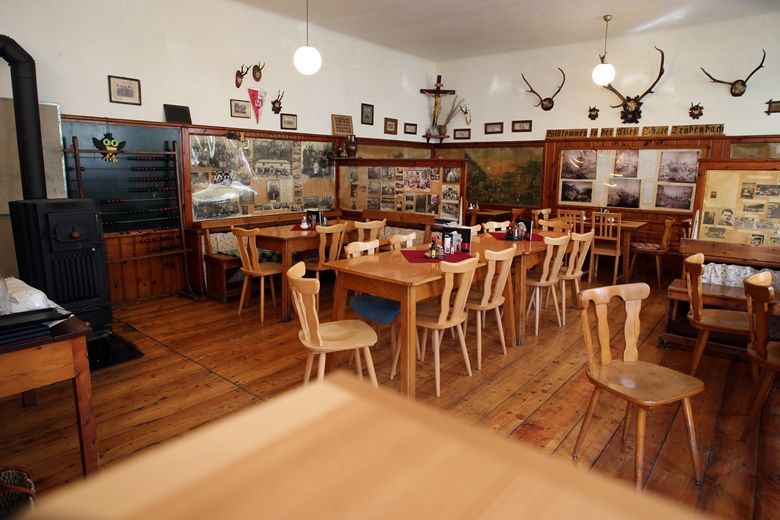Interior view of a rustic restaurant with wooden furniture and wall decorations.