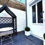 Entrance area with white door, black bench with canopy and small table.