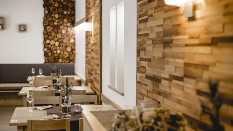 Cozy restaurant with wooden walls and decorated tables.