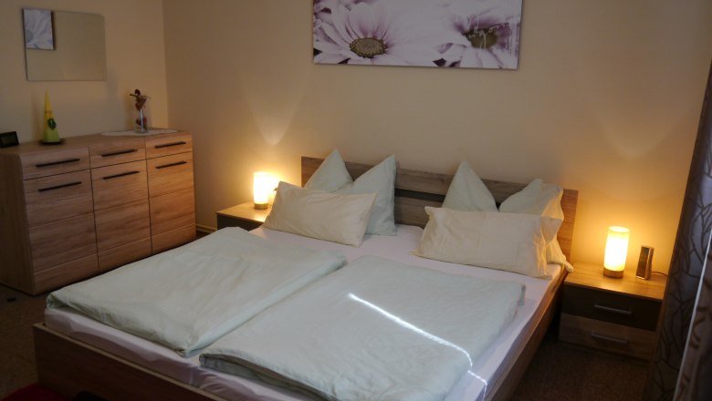 Comfortable bedroom with double bed, bedside lamps and chest of drawers.