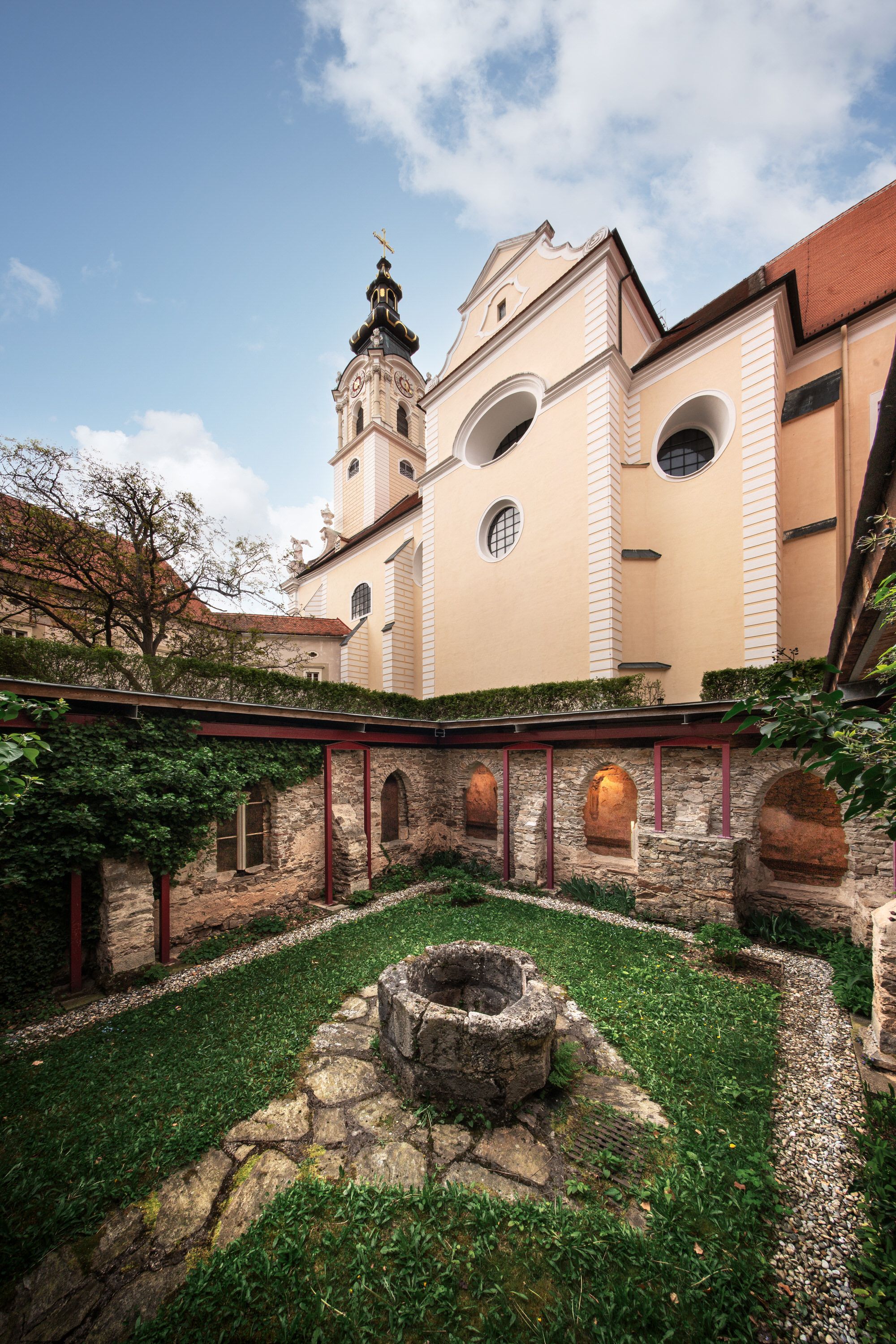 Inner courtyard of Altenburg Abbey with fountain and church tower in the background.