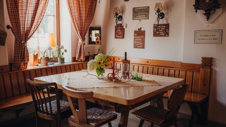 Cozy guest room with wooden table, chairs and decorative elements on the walls.