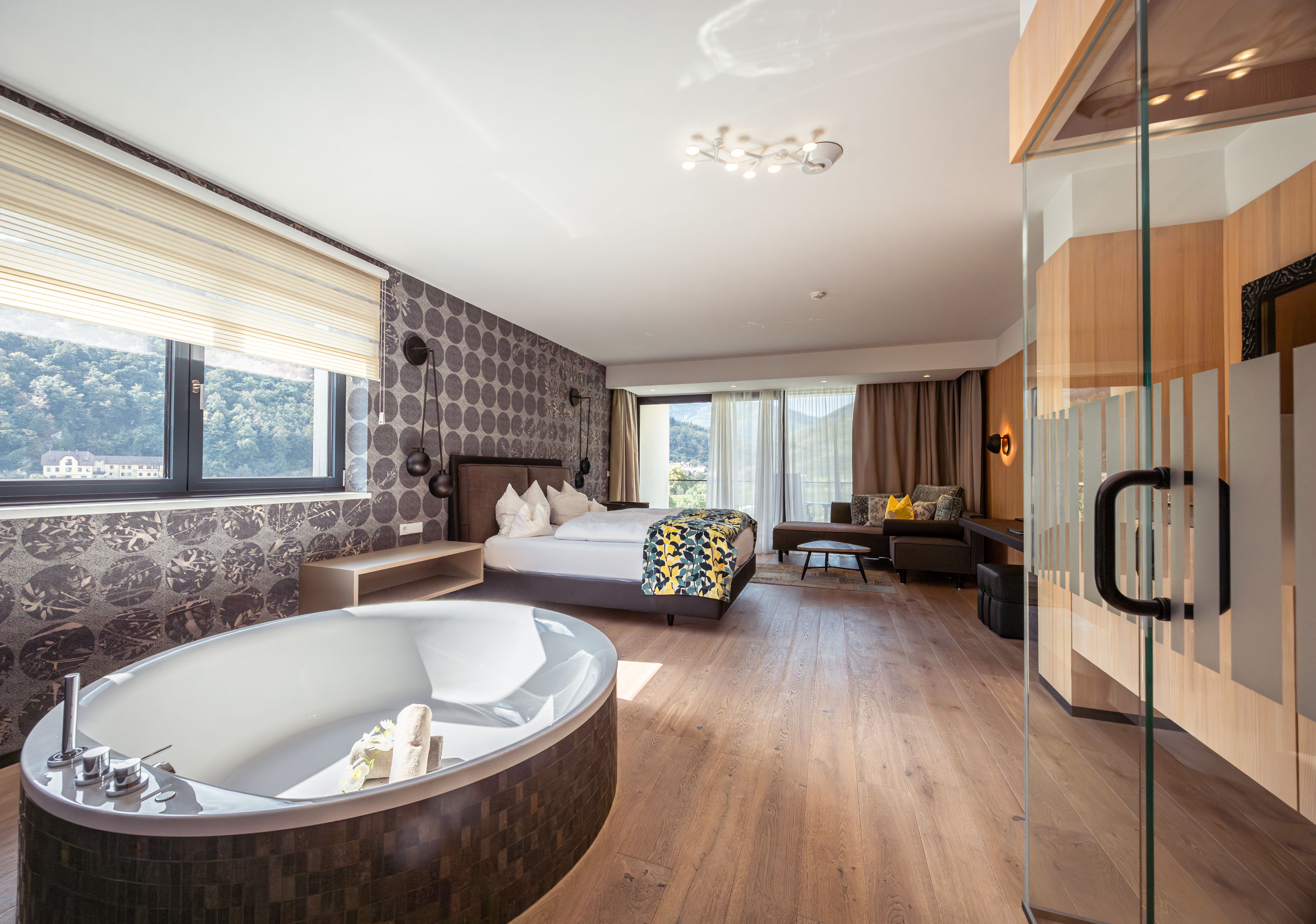 Exterior view of a modern hotel with pool and sun loungers.