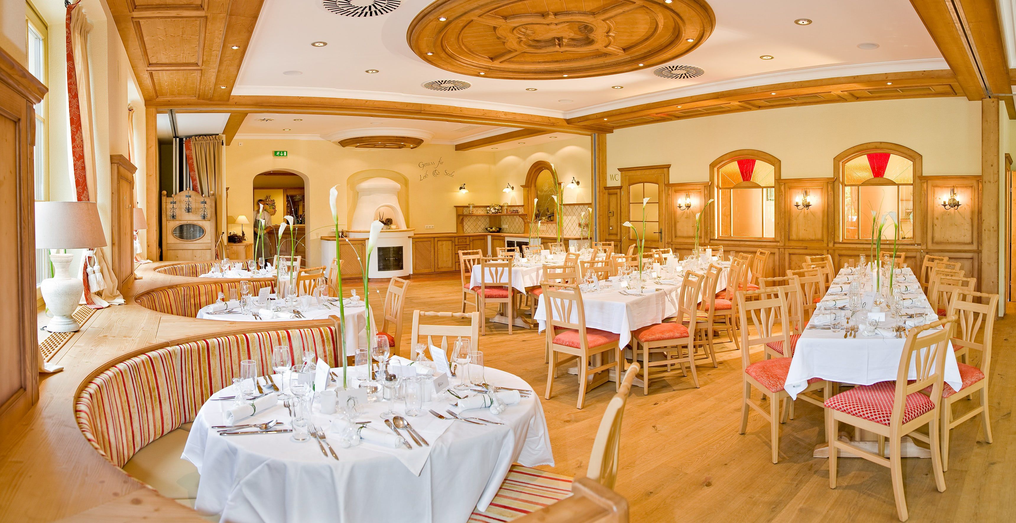 Elegant ballroom with laid tables and wooden furnishings.