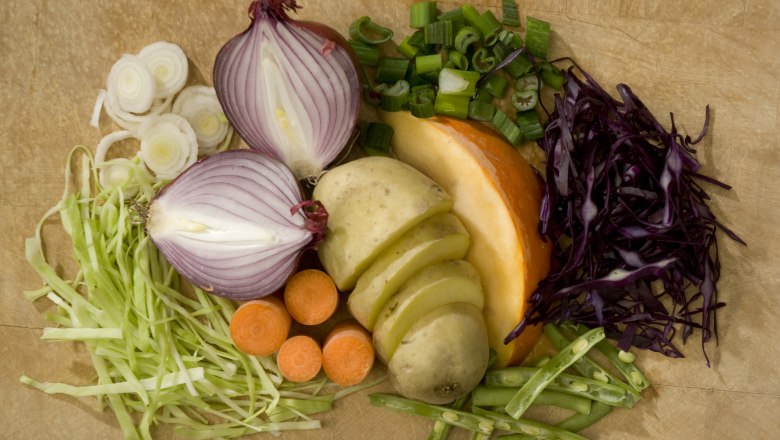 Various vegetables arranged on a wooden board.