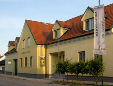 Yellow building of a winery with red roof and flag.