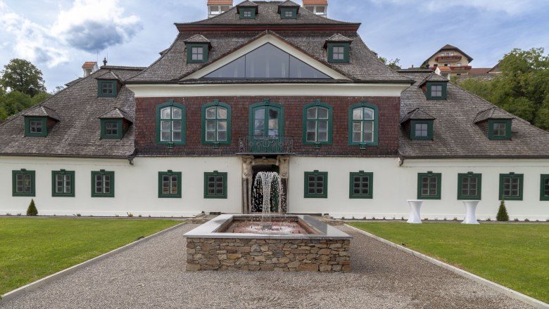 Exterior view of Schloss Luberegg with fountain in the foreground.