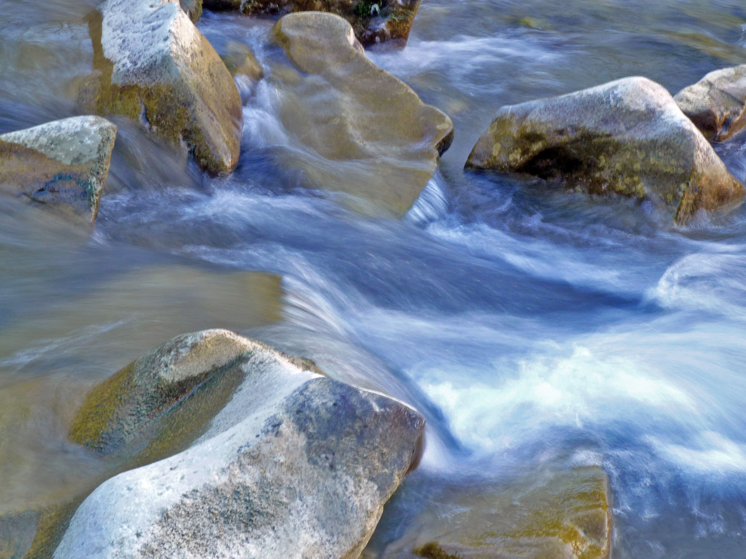 Flowing water over stones in a stream.
