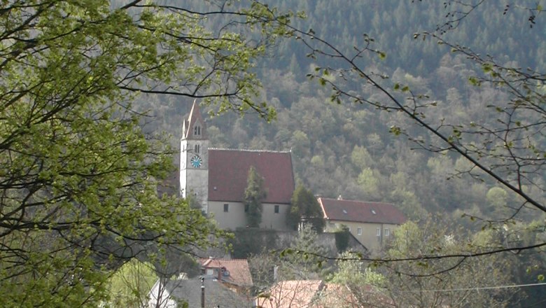 Senftenberg parish church surrounded by trees and hills.