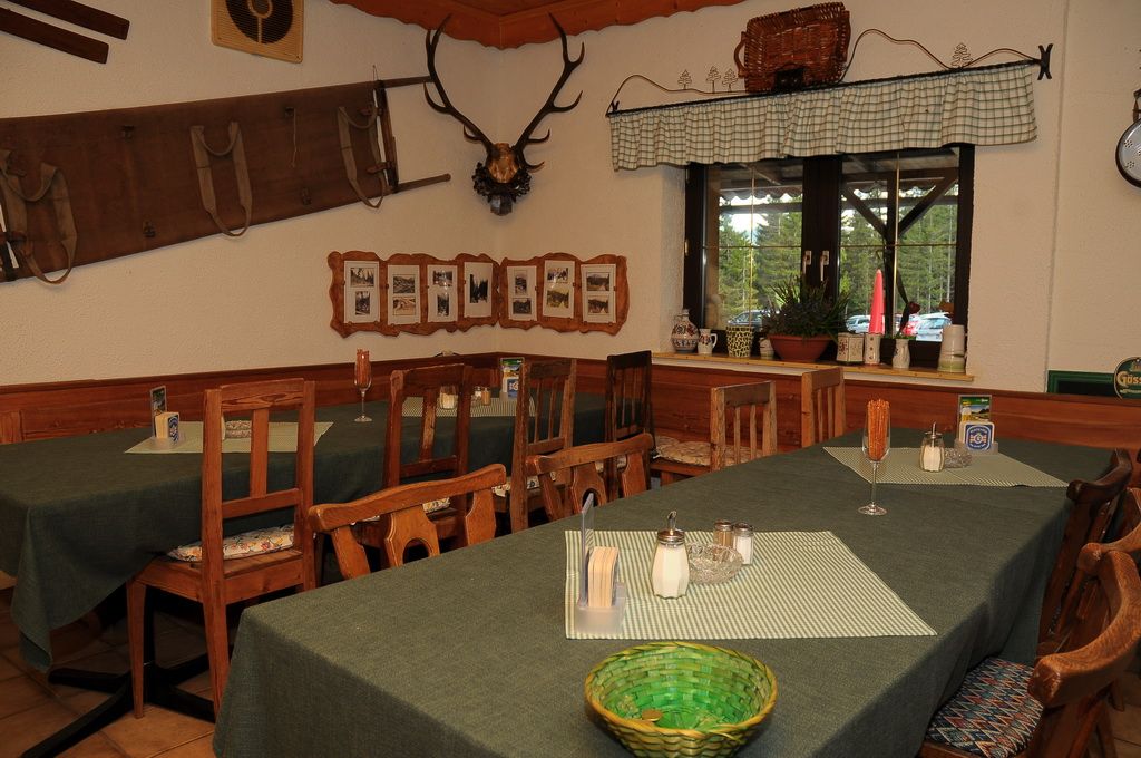 Interior view of a rustic mountain hut with wooden furniture and decorations.