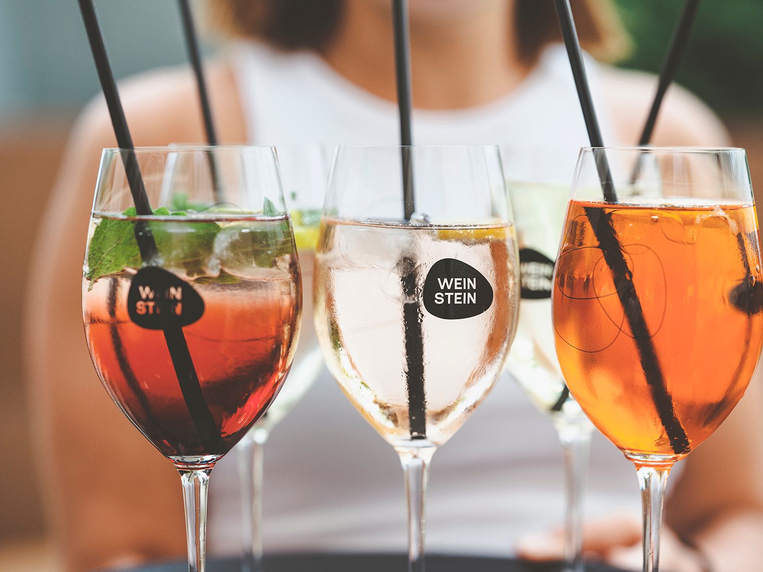 Close-up of wine glasses with various drinks and straws.