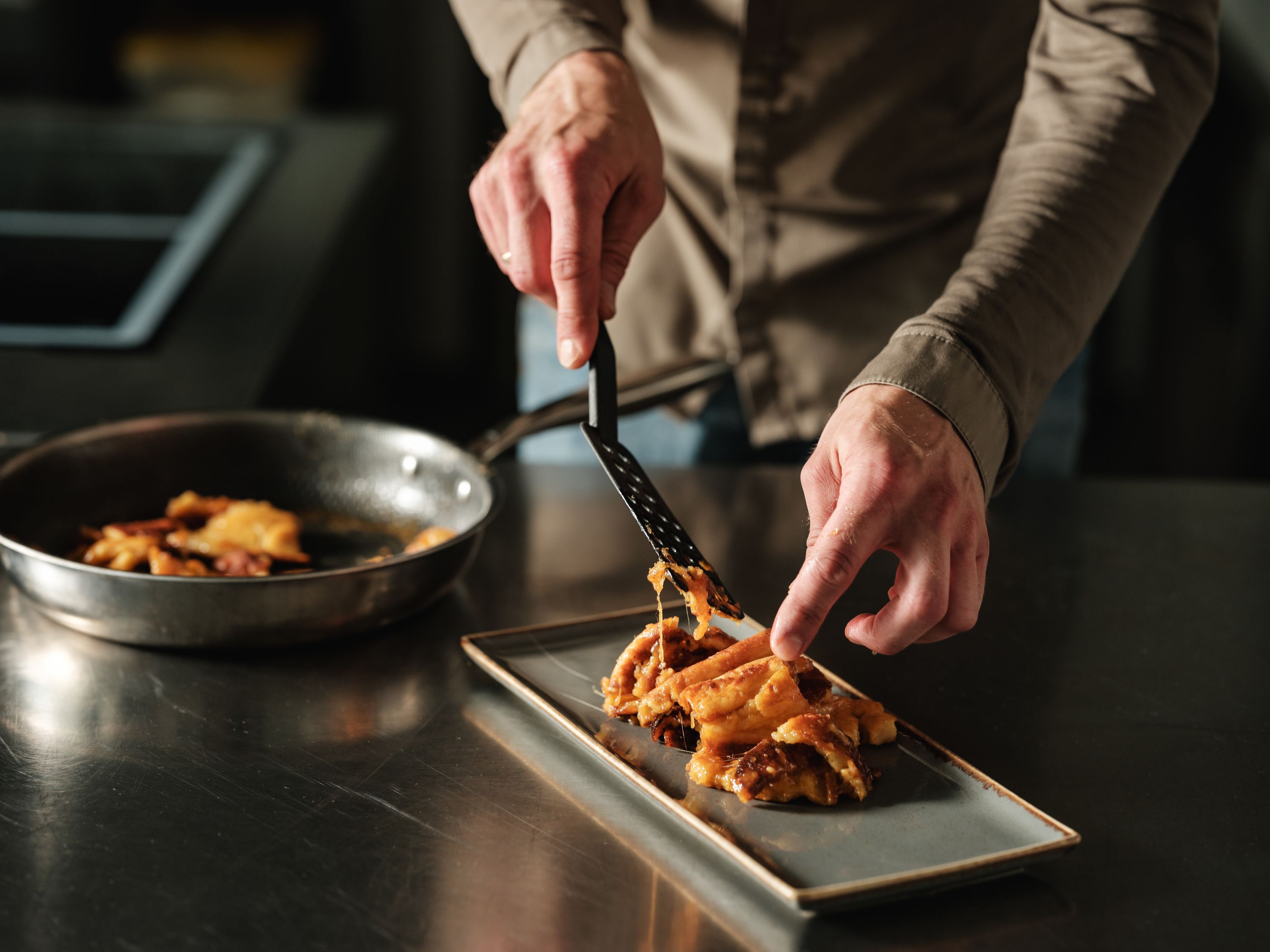 Person arranges food on a rectangular plate.