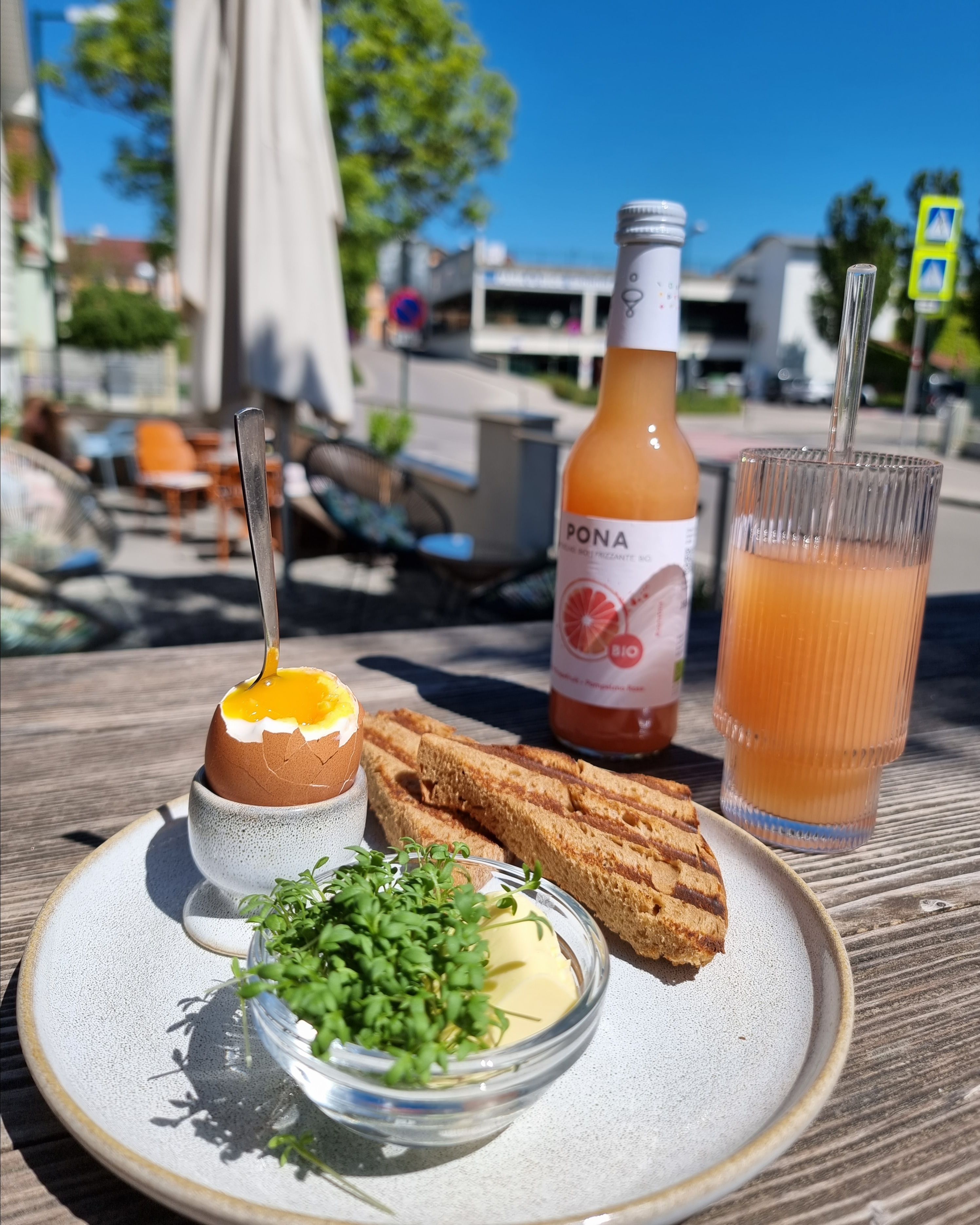 Toast, boiled egg and juice at the table in the outdoor area