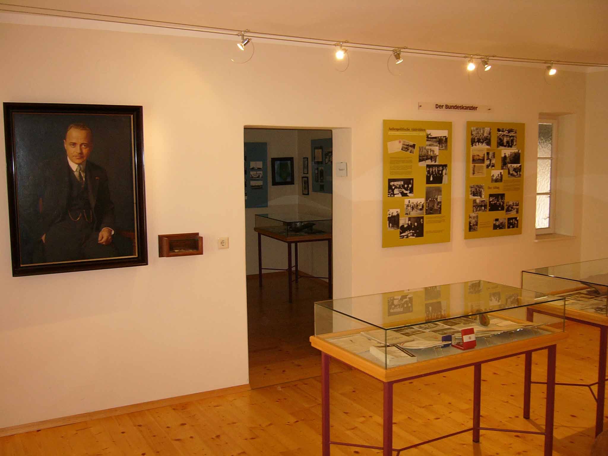 Interior view of a museum with portrait and exhibition panels.