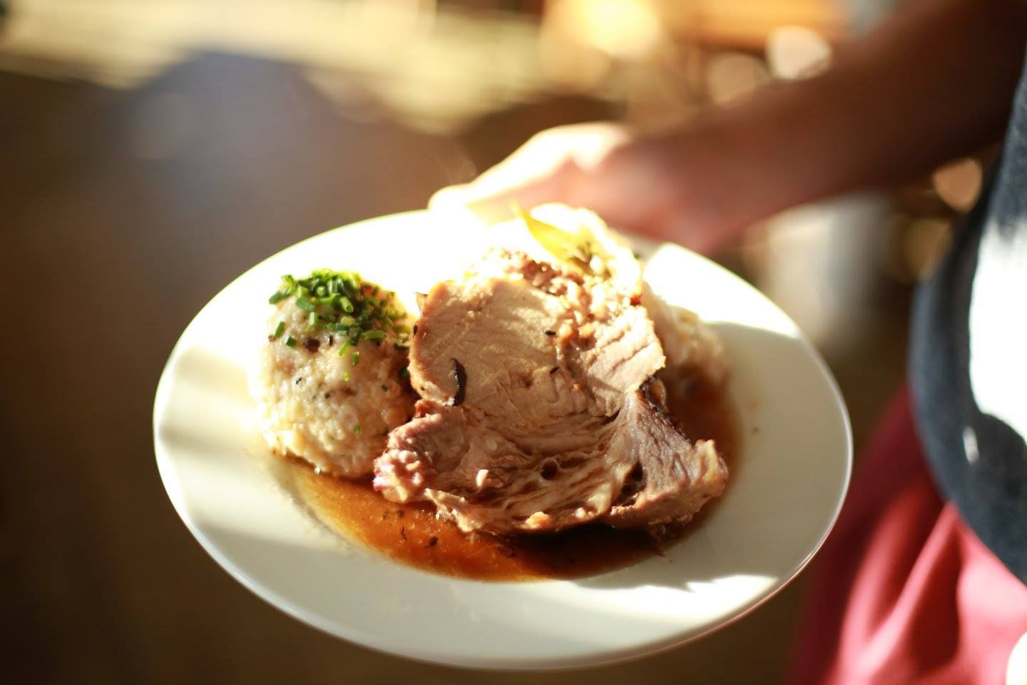 A plate with roast, dumplings and gravy.