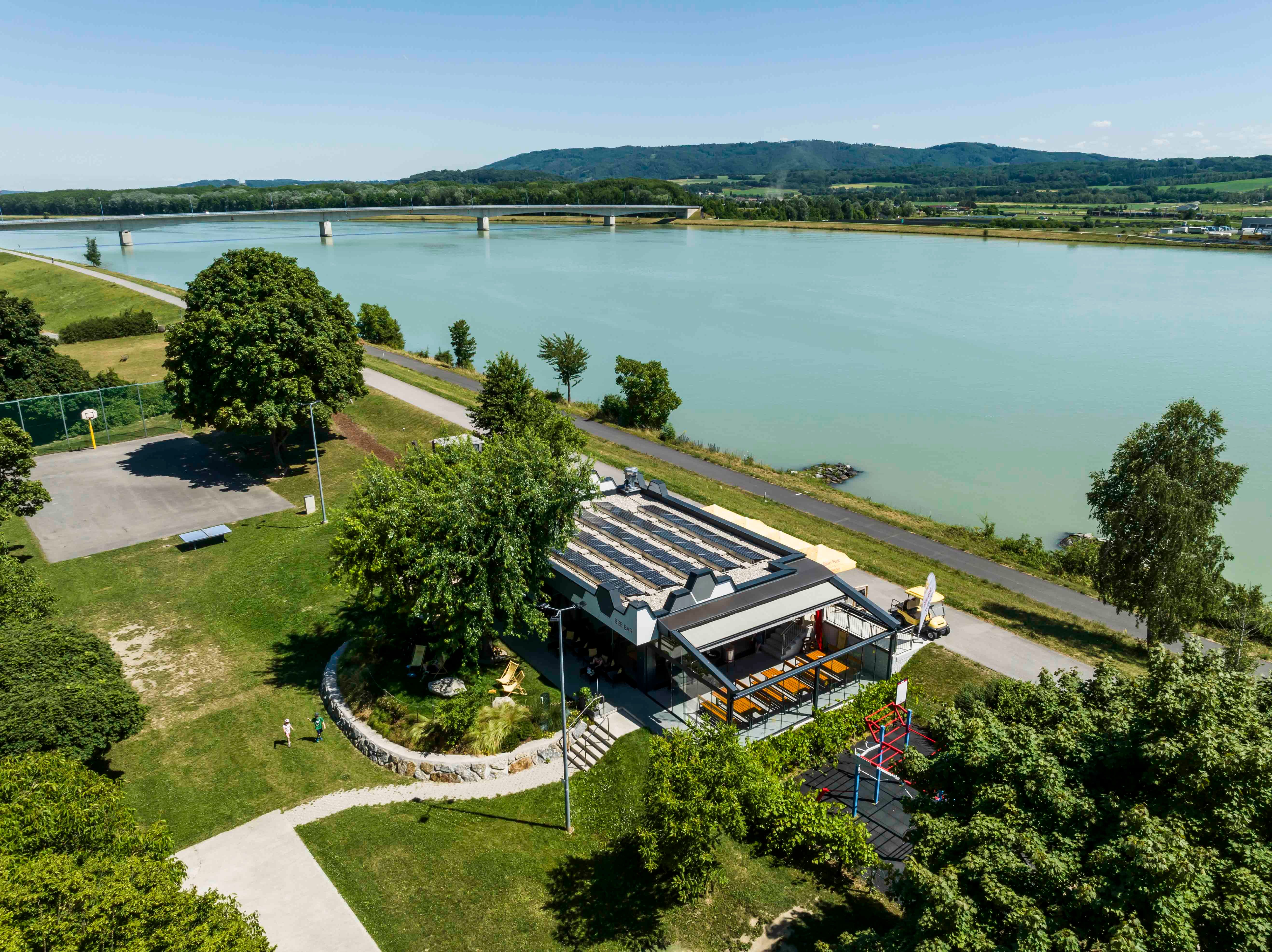 Aerial view of the Bee-Bar in Klein-Pöchlarn on the riverbank with surrounding landscape.