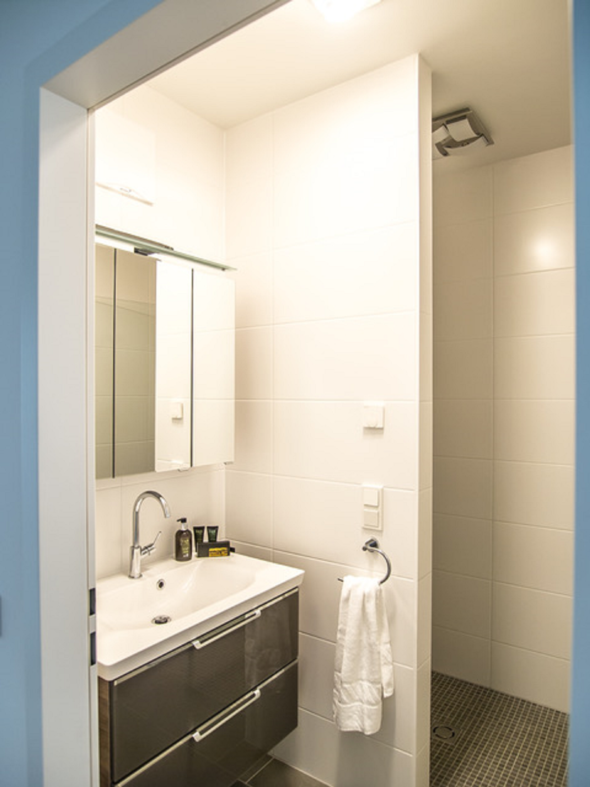 bright, inviting bathroom with washbasin and shower 