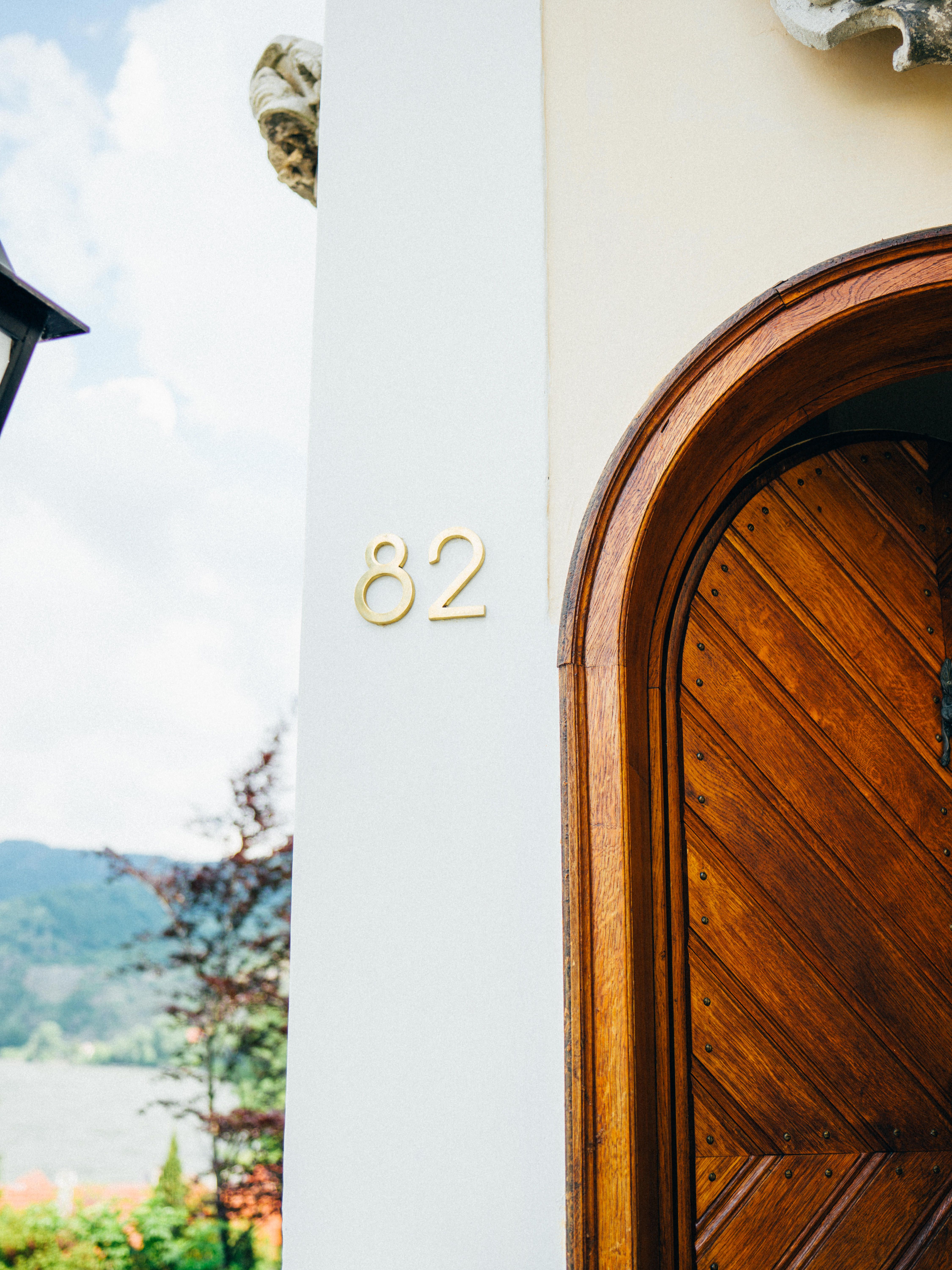Wooden door with house number 82 and landscape in the background.