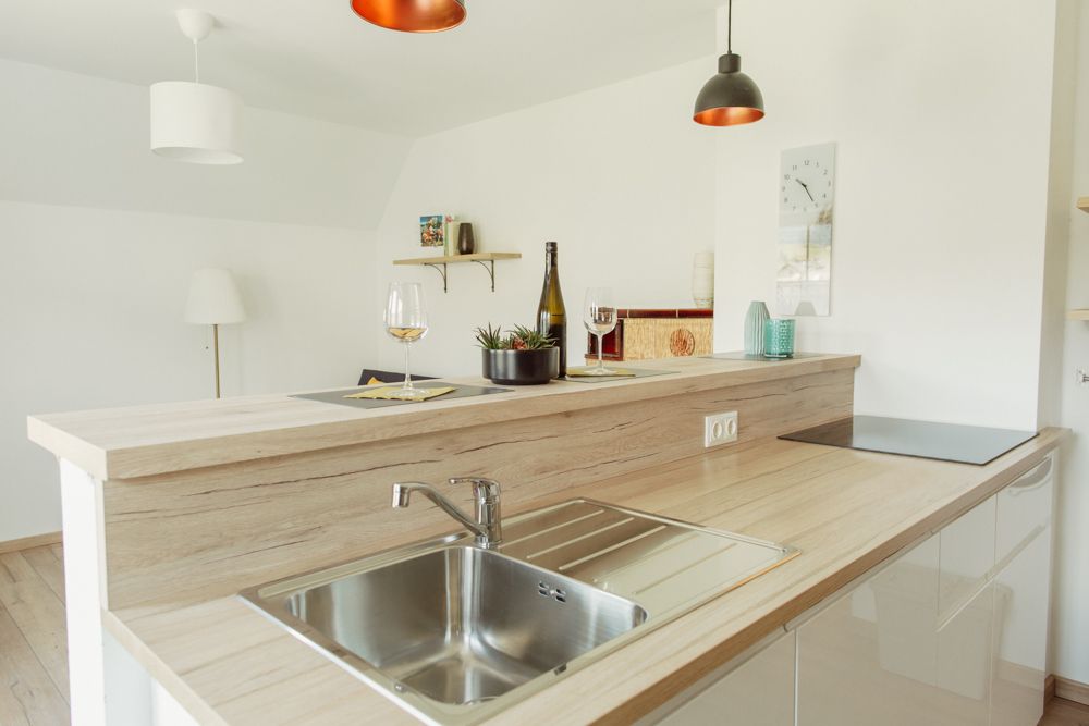 Modern kitchen with wooden worktop, sink and decoration.