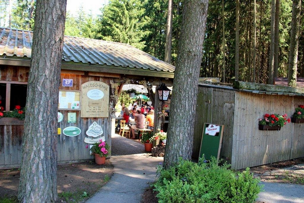 Entrance to a forest tavern with wooden hut and flowers.