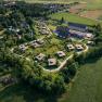 Aerial view of Grafenegg Cottages surrounded by green countryside and fields.